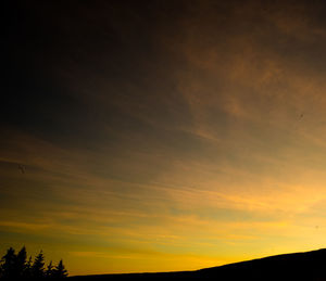 Low angle view of silhouette landscape against sky at sunset