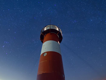 Low angle view of lighthouse against sky at night