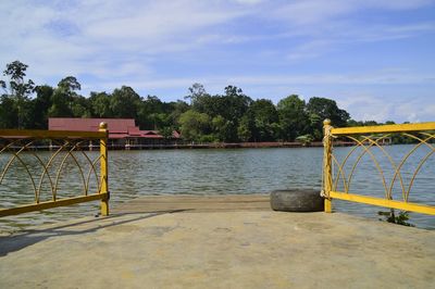 Gazebo by lake against sky