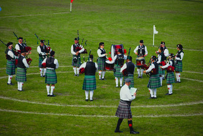 Group of musicians playing musical instruments on grassy field