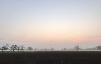 Electricity pylon against sky during sunset