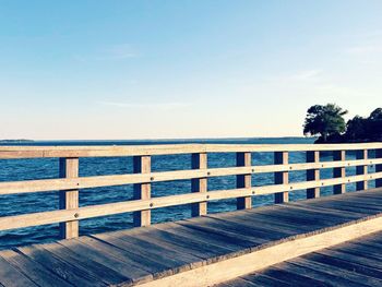 Wooden boardwalk on beach against sky