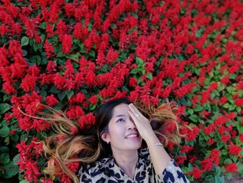 Portrait of beautiful young woman in red flowering plants