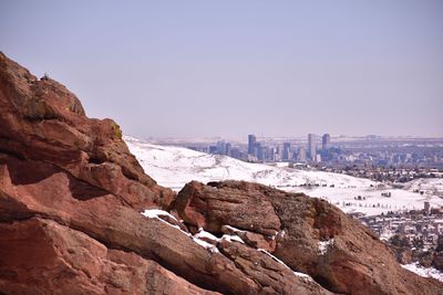 Rock formations in city against clear sky