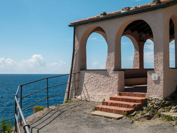 Built structure by sea against sky