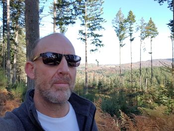 Portrait of man wearing sunglasses in forest