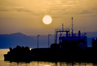 Silhouette pier over sea against sky during sunset