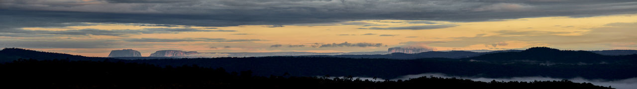 Silhouette of trees against cloudy sky