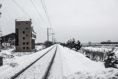 Snow covered railroad tracks against sky