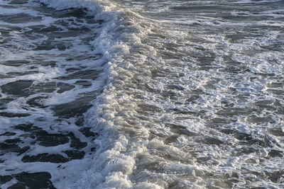 High angle view of waves rushing towards shore