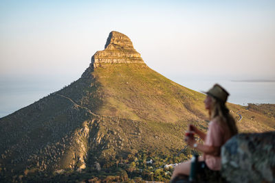 Low angle view of person on rock against sky