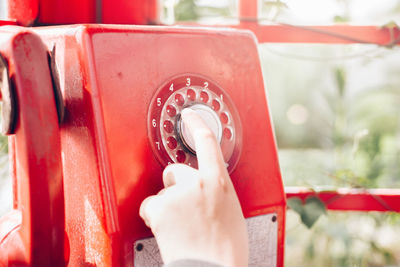 Close-up of human hand on red metal