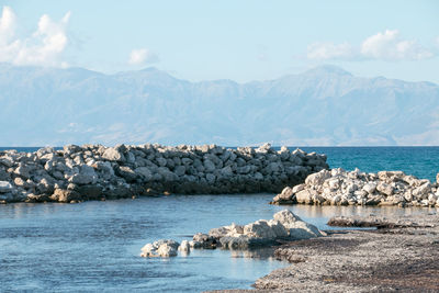 Scenic view of sea and mountains against sky