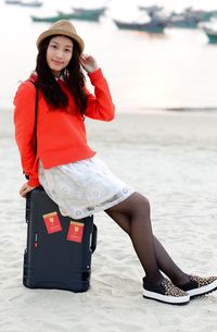 Full length of woman sitting on beach