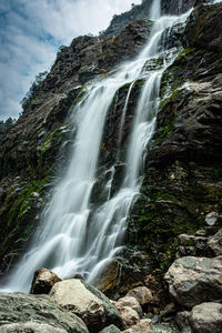 Waterfall white water stream falling from mountains at day from flat angle