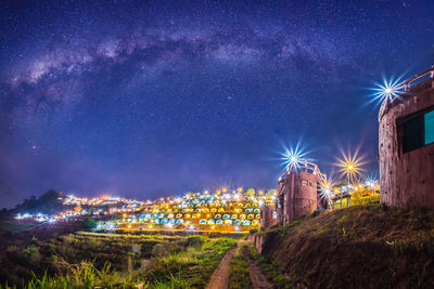 Illuminated buildings against sky at night