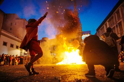 Group of people against buildings in city at night