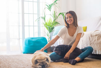 Smiling owner playing with dogs at home