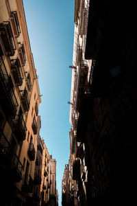 Low angle view of buildings against clear sky in city