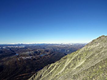 Scenic view of mountains against clear blue sky