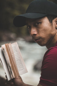 Portrait of young man reading book