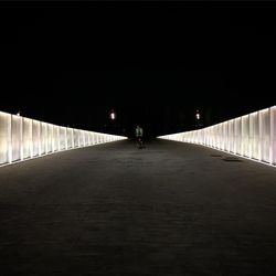 Full length of woman walking on illuminated road