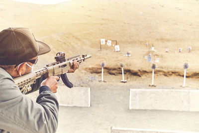 Men practicing shooting with a assault rifle at target. selective focus