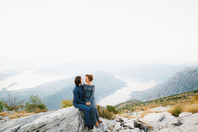 Rear view of man on mountain against sky