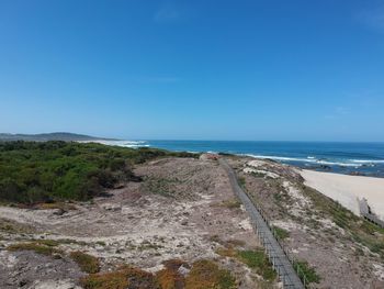 Scenic view of beach against clear blue sky