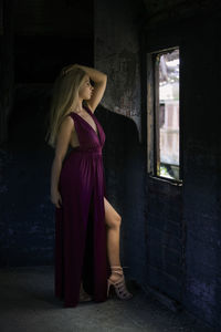 Woman looking away while standing in abandoned building