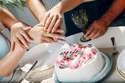 Midsection of woman cutting cake