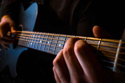 Close-up mid section of man playing guitar