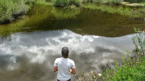 Rear view of man fishing at lake