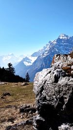 Scenic view of snowcapped mountains against clear blue sky