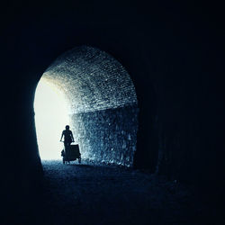 Silhouette man in tunnel at night