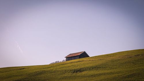 House on field against clear sky