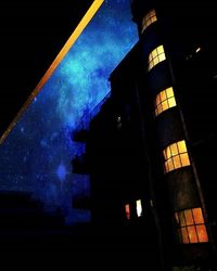 Low angle view of buildings against sky at night