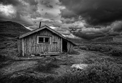 Abandoned house on field against sky