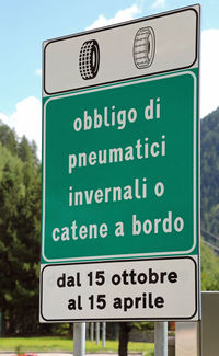 Close-up of road sign against sky