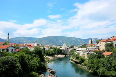 River amidst buildings in town against sky