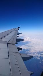 Cropped image of airplane wing flying over landscape