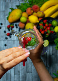 Cropped hand of woman holding fruit