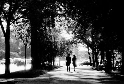 Rear view of people walking on footpath