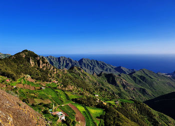 Scenic view of mountains against clear blue sky