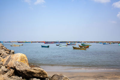 Boats moored on sea against sky