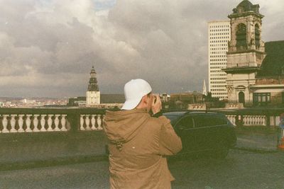 Rear view of a man with cityscape in background