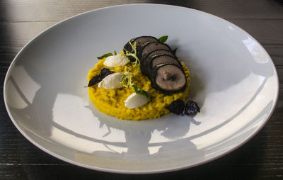 Close-up of meat with corn porridge served in plate on table