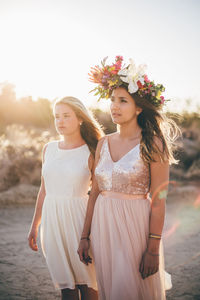 Friends standing at beach against sky