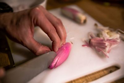 Close-up of hand chopping onion