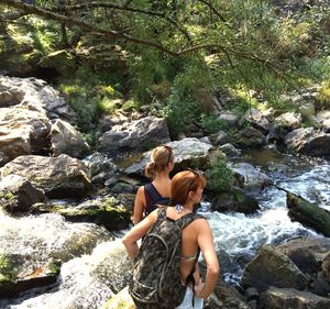 Woman sitting on rocks in forest